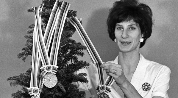  Irena Kirszenstein (Szewińska) w swoim mieszkaniu z choinką i medalami zdobytymi na Igrzyskach Olimpijskich w Tokio, 11.12.1964 r.  