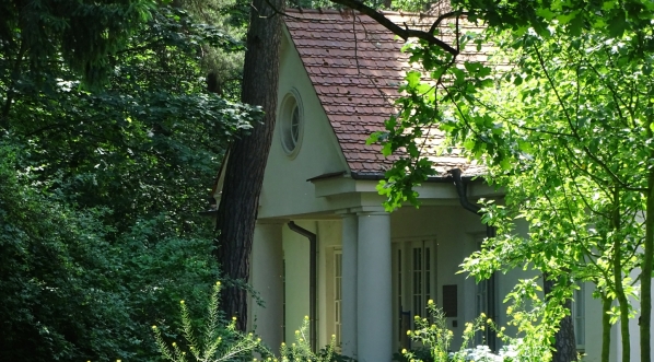  Zanurzony w zieleni ganek dworku Milusin w kompleksie Muzeum Józefa Piłsudskiego w Sulejówku.  