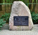 Kamień i tablica upamiętniająca Mariana Rajewskiego, Jerzego Różyckiego i Henryka Zygalskiego w Lesie Kabackim w Warszawie.
