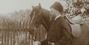 Karol Lanckoroński w stroju narodowym trzymający za wodze konia.