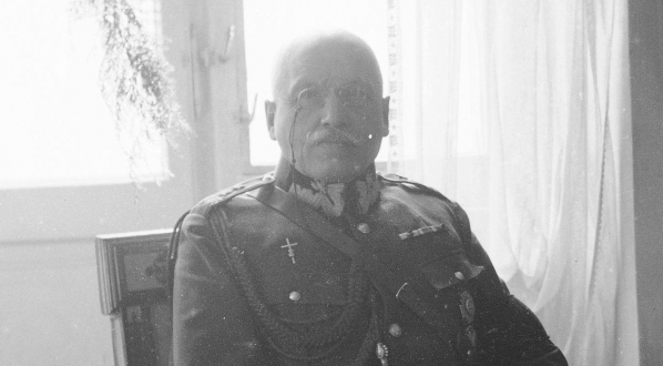  Gen. Jan Jacyna siedzi w fotelu przed kominkiem.  