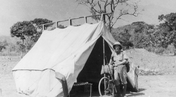  Podróżnik Kazimierz Nowak z rowerem stoi przy namiocie poszukiwaczy złota.  